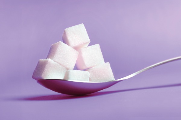 Cuillère contenant des morceaux de sucre blanc